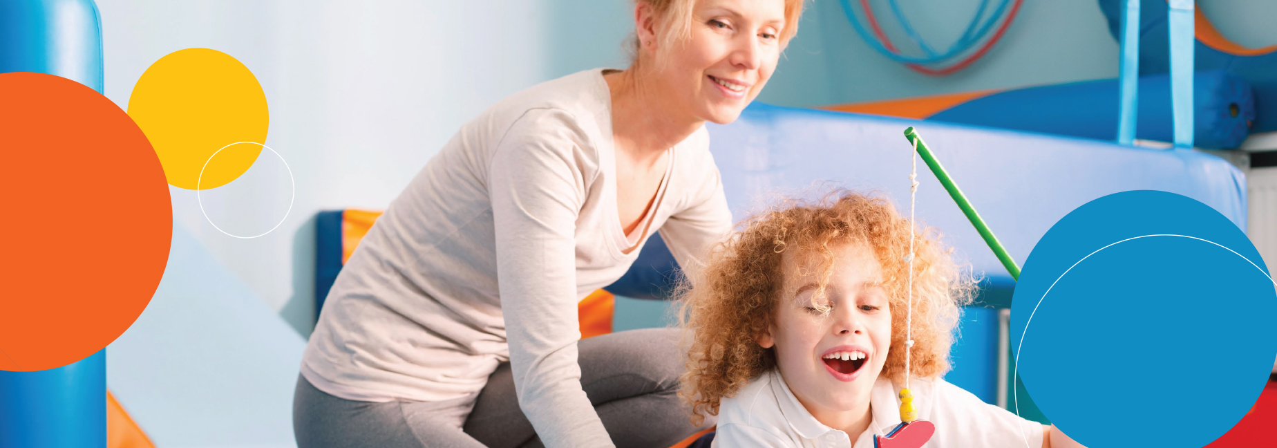 Child and woman smiling while looking at a toy